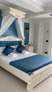 a bedroom with a large bed with blue pillows at Luxury by White Titanic Breeze in Năvodari +37 photos