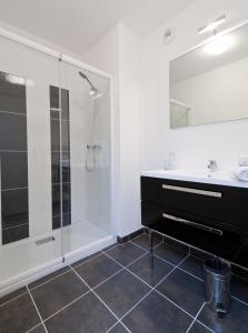 bagno con doccia e lavandino di Ténéo Apparthotel Talence Arthena a Talence