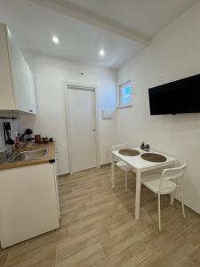 a kitchen with a table and a sink and a table and chairs at Casette in centro Por Siempre Cuatro House in Ischia +5 photos
