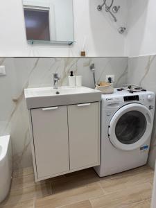 a bathroom with a washing machine and a sink at Casette in centro Por Siempre Cuatro House in Ischia