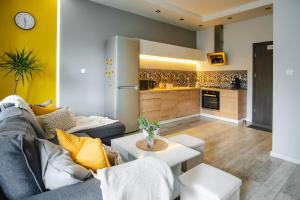a living room with a couch and a kitchen at Słoneczny Apartament in Duszniki Zdrój