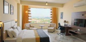 a hotel room with a bed and a large window at Regenta Central Mewargarh, Near Biological park in Udaipur