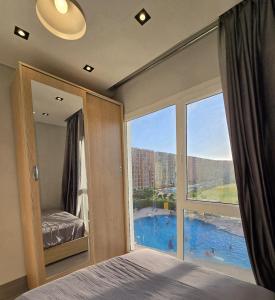 a bedroom with a large window with a view of a pool at Luxury chalet in Porto Golf for rent in El Alamein