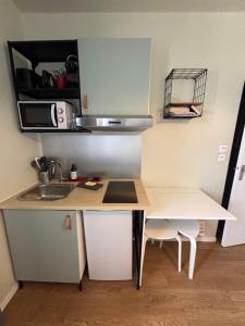 una pequeña cocina con escritorio y fregadero en Appart du Théâtre, en Caen