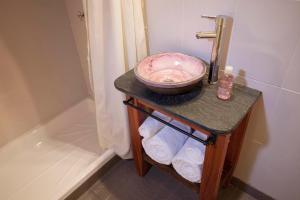 a bathroom with a sink and a bowl on a table with towels at En el Taller in San Salvador de Jujuy