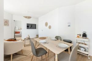 Una sala de estar blanca con una mesa y sillas. en Bord de l'eau 4 -Vue Mer - 3 personnes, en Cancale