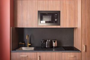 a kitchen with a sink and a microwave at Sol hotel St Mande - 4 personnes - 11 in Saint-Mandé