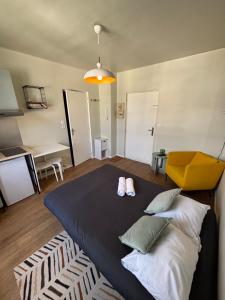 Un dormitorio con una cama y una silla amarilla. en Appart du Théâtre, en Caen