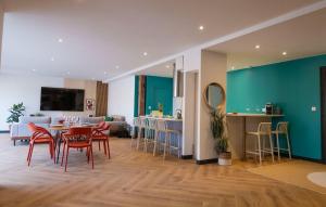 a living room with a table and chairs and a kitchen at L'Escapade d'Acquigny, Piscine, Foot Five, Salle de sport, BabyFoot in Acquigny