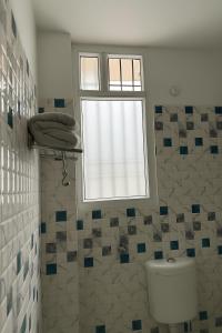 a bathroom with a toilet and a window at Hotel Siddhartha Gautama in Patna