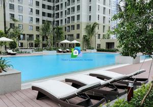 a group of lounge chairs next to a swimming pool at Condo Masteri Thao Dien in Ho Chi Minh City