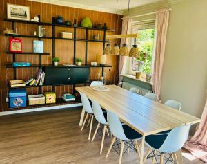 a dining room with a wooden table and chairs at Heldendomizil in Hattstedt