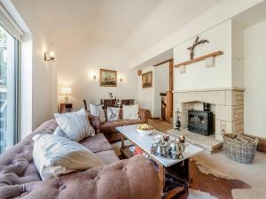 a living room with a couch and a fireplace at Ellen Cottage in Burford