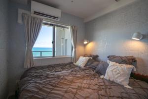 Postel nebo postele na pokoji v ubytování オーシャンビューサニーオキナワ