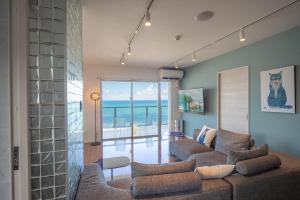 a living room with a couch and a view of the ocean at オーシャンビューサニーオキナワ in Kin