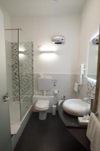 a bathroom with a sink and a toilet and a shower at B&B Napolimilionaria Foria 242 in Naples