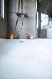 a bathroom with a shower with two candles in it at The Sandford Park Townhouse 6 Bed Sleeps 12 Entire Apartment in Cheltenham