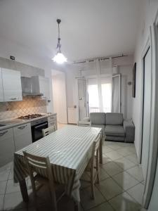 a kitchen and living room with a table and a couch at SA HOUSE in Barletta +12 photos