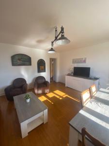 a living room with a couch and a table at BEAU DUPLEX 80 m2 100 metre de la plage in Hermanville-sur-Mer