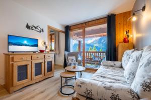 a living room with a couch and a tv at A203- Appartement 2 pieces cabine 6 personnes in Orcières