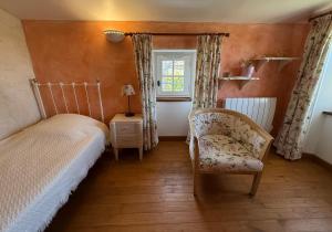 a bedroom with a bed and a chair and a window at Chambre d'hôtes Les Bleuets in Melle
