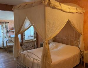 a bedroom with a canopy bed in a room at Chambre d'hôtes Les Bleuets in Melle