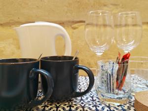 a table with two coffee cups and wine glasses at Kamra Maltija in Sliema
