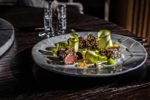 a plate of food on a wooden table at Hotel Ambasador - Liburnia in Opatija