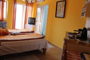 a yellow room with two beds and a television at Judit haus in Balatonfüred +8 photos