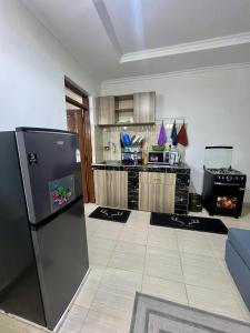 a kitchen with a refrigerator and a stove at Elite suite 1bedroom in Busia +21 photos