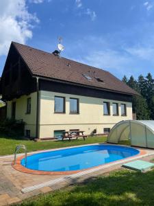 a house with a swimming pool in front of it at Dum Eva in Janske Lazne