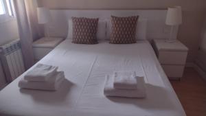 a large white bed with two boxes on it at Tu refugio en Málaga, confort y ubicación perfecta in Málaga