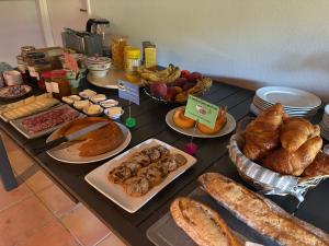 a table topped with different types of bread and pastries at La Dolce Vita Montauroux in Montauroux
