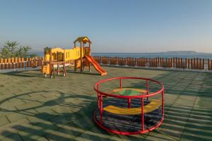 a playground with a slide and a play structure at Themis Beach Hotel in Kokkini Khanion