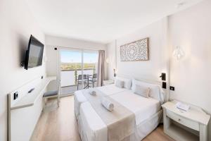 a white bedroom with a large bed and a balcony at Hotel Ankaa - Adults Only in Porto Cristo