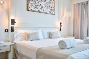 a hotel room with two beds and a picture on the wall at Hotel Ankaa - Adults Only in Porto Cristo