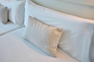 a white couch with white pillows on it at Hotel Ankaa - Adults Only in Porto Cristo