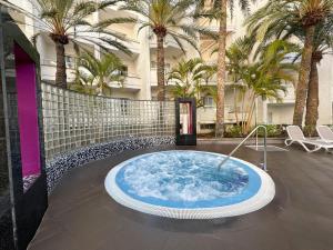 a hot tub in the middle of a courtyard with palm trees at Servatur Don Miguel - Adults Only in Playa del Ingles