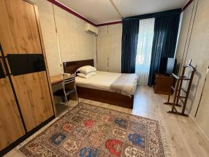 a small bedroom with a bed and a rug at Heyvah - Guest House in Tashkent in Tashkent +13 photos