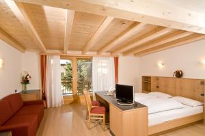 a bedroom with a bed and a desk with a computer at Hotel Pider in La Valle