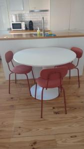 a white table and four red chairs in a kitchen at Apartamento ideal en Málaga in Málaga