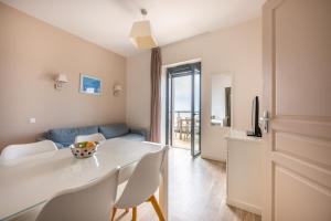 a living room with a white table and chairs at Résidence Odalys De La Plage in Pornichet