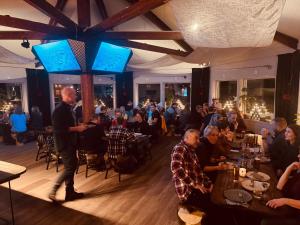 un groupe de personnes assises à des tables dans un restaurant dans l'établissement Kittelfjäll Vandrarhem, à Kittelfjäll
