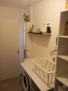 a laundry room with a washing machine and a laundry basket at maison de campagne avec terrasse et vue dégagée in Cusset