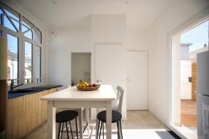 une cuisine avec une table avec un bol de fruits dessus dans l'établissement Aux Trois Mousquetaires - proche Jardin Dumaine, à Luçon