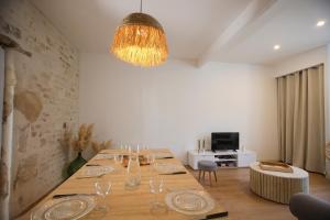 une salle à manger avec une grande table et un lustre dans l'établissement Aux Trois Mousquetaires - proche Jardin Dumaine, à Luçon 5 autres photos