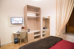 a bedroom with a bed and a desk and a television at B&B Napolimilionaria Foria 242 in Naples +34 photos