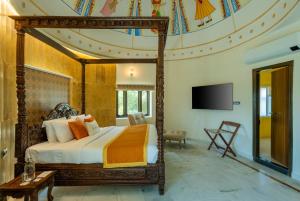 een slaapkamer met een hemelbed en een televisie bij Zone Connect by The Park Jaisalmer in Jaisalmer