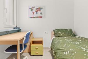 a bedroom with a desk and a bed with a green bedspread at Apartments Kana in Pula