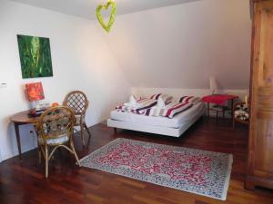 a bedroom with a bed and a table and chairs at Au Coeur Du Vignoble in Orschwiller